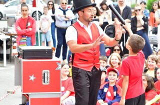 Mago Taz con la tuba e un giovane assistente nella festa di piazza a Carcare