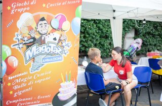 Animatrice trucca un bimbo sul viso da uomo ragno