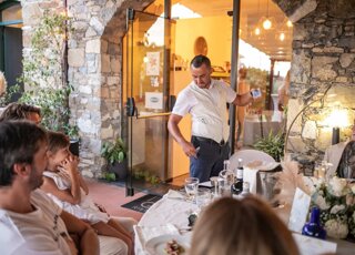 Mago Taz intrattiene il pubblico ritrovando la carta nella tasca alla festa nuziole