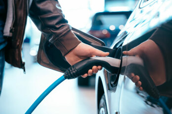 human-hand-is-holding-electric-car-charging-connect-electric-car-555x370.jpeg