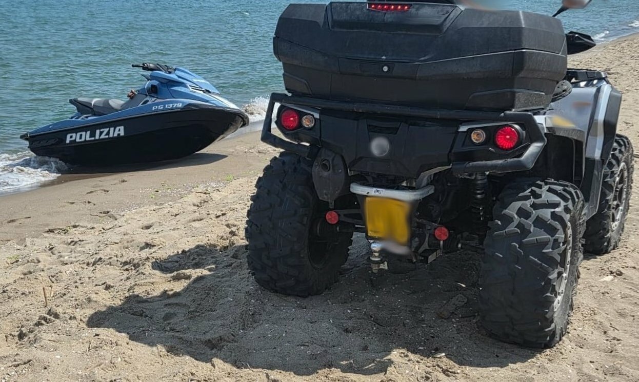 Col quad sulla spiaggia per fare un tuffo in mare