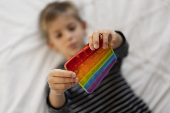 close-up-child-playing-with-pop-it-toy.jpeg