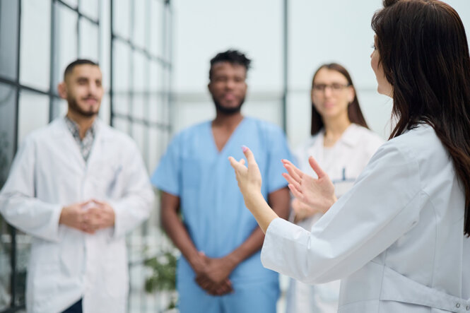 la-donna-medica-sta-con-la-schiena-e-insegna-con-i-colleghi.jpeg la-donna-medica-sta-con-la-schiena-e-insegna-con-i-colleghi.jpeg