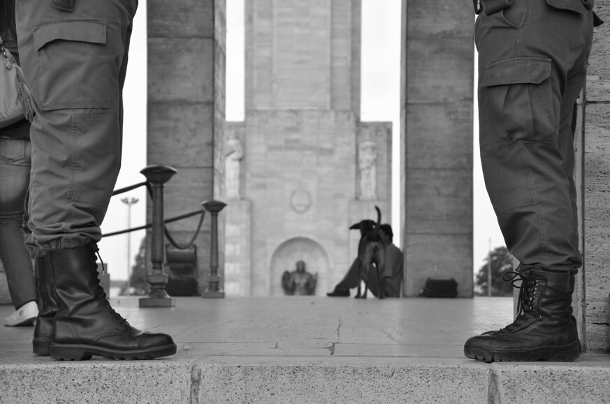 Primo piano di stivali militari con monumento sullo sfondo Primo piano di stivali militari con monumento sullo sfondo