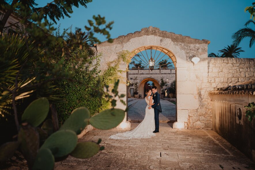 Luxury destination wedding in Sicily with couple under rustic archway