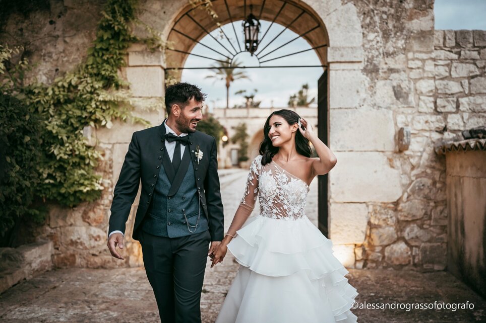 Bride and groom walking hand in hand at a luxurious Sicilian wedding.