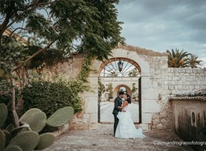 Couple kissing in a rustic courtyard during their Sicily destination wedding.