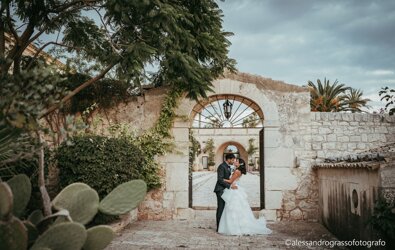 Couple kissing under an archway during a luxury wedding in Sicily.