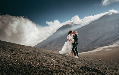 Luxury wedding couple embracing on Mount Etna, Sicily with volcanic landscape