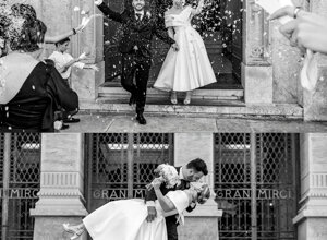Couple celebrating wedding with confetti and romantic kiss in front of a historic building.