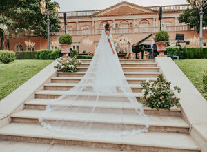 Bride on elegant staircase in front of luxurious villa, Sicily weddings