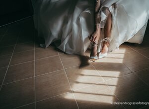 Bride adjusting elegant wedding shoes on her special day in Sicily