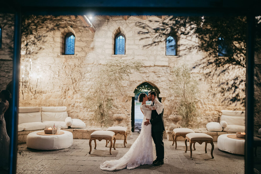 Luxury wedding in Sicily with a couple embracing in an elegant stone villa