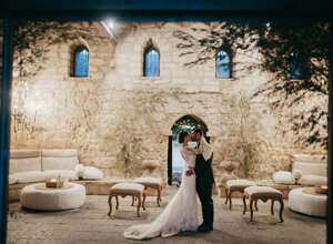 Couple sharing a romantic moment in a historic stone venue, ideal for Sicily weddings.