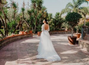 Bride in elegant white dress in lush Sicilian garden during luxury destination wedding