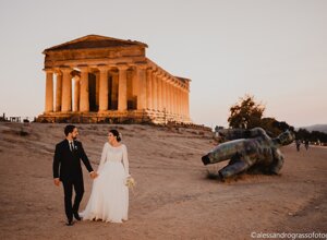 Bride and groom walking hand in hand at the Valley of the Temples, Sicily at sunset.