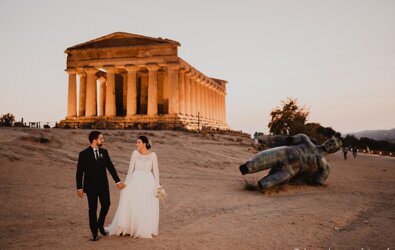 Luxury wedding couple in front of ancient Sicilian temple during sunset