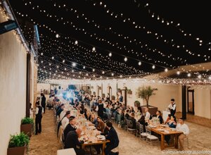 Elegant evening wedding reception in Sicily with string lights and guests dining outdoors.