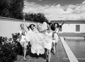 Bridesmaids and bride joyfully celebrating by the poolside during a Sicily wedding