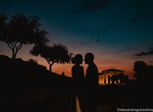 Silhouette of a couple at sunset near an ancient temple in Sicily