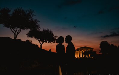 Silhouette of a couple at sunset in front of a historic temple, perfect for luxury Sicilian destination weddings.
