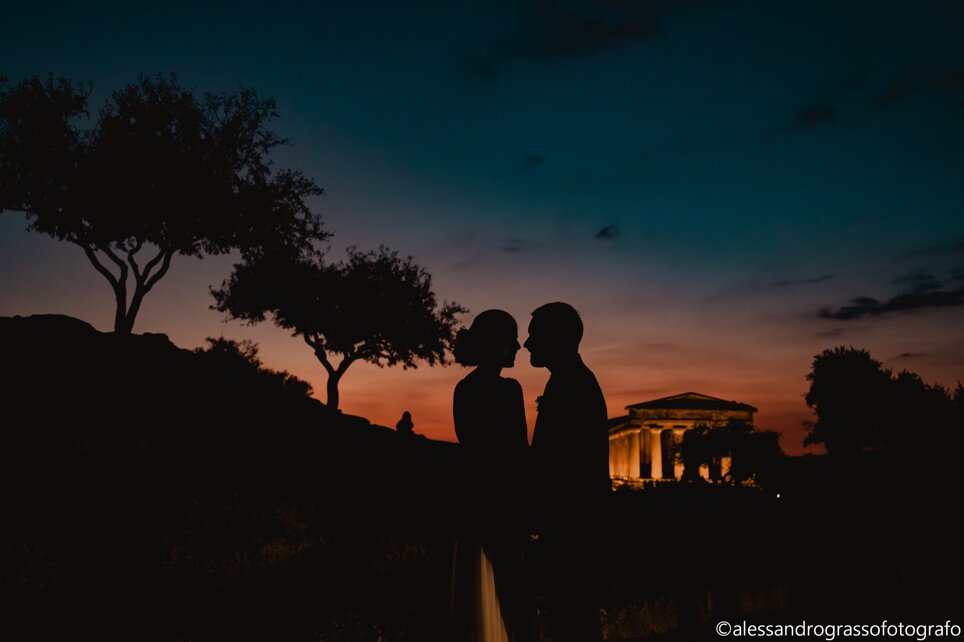 Silhouette of a couple at sunset near a temple, ideal for Sicilian destination weddings