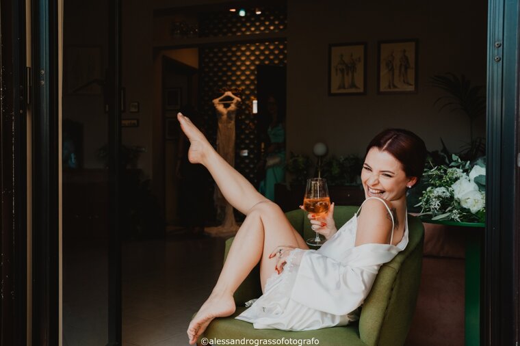 Bride smiling with a drink before her Sicilian wedding