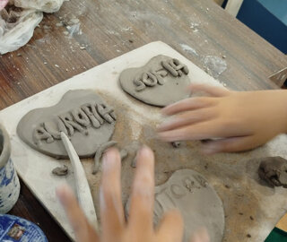 eyJlcyI6Ik1hbm9zIGRlIG5pJiN4RjE7byB0cmFiYWphbmRvIGNvbiBhcmNpbGxhIGVuIGZvcm1hIGRlIGNvcmF6JiN4RjM7biBjb24gbm9tYnJlcyJ9