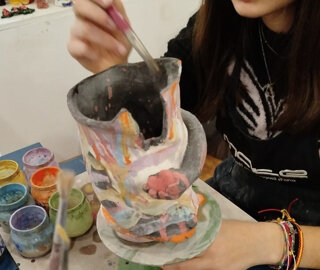 eyJlcyI6IlBlcnNvbmEgcGludGFuZG8gdW4gamFyciYjeEYzO24gZGUgY2VyJiN4RTE7bWljYSBjb24gY29sb3JlcyB2aWJyYW50ZXMgeSBjcmVhdGl2aWRhZC4ifQ==