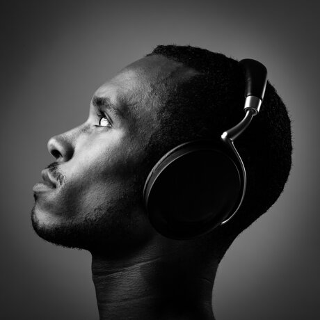 side-view-young-man-listening-music-with-headphones-black-background.jpeg
