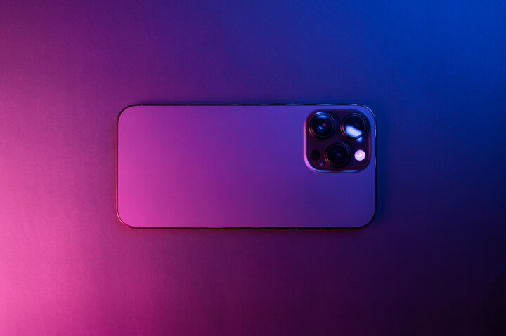 closeup-iphone-14-pro-max-space-black-isolated-black-background-illuminated-by-blue-pink-lights-low-light-3-featured-cameras-selective-focus.jpeg