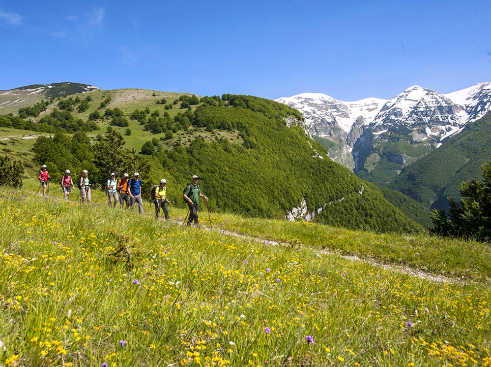 Gruppo di escursionisti che cammina nel Parco Nazionale della Maiella con vista sulle montagne innevate