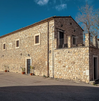 Edificio storico in pietra a San Valentino Abruzzo sotto un cielo blu