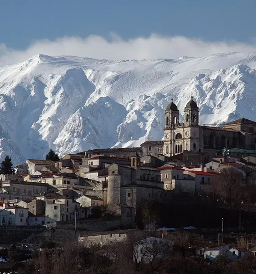 Paesaggio invernale di un borgo storico in Abruzzo con montagne innevate sullo sfondo