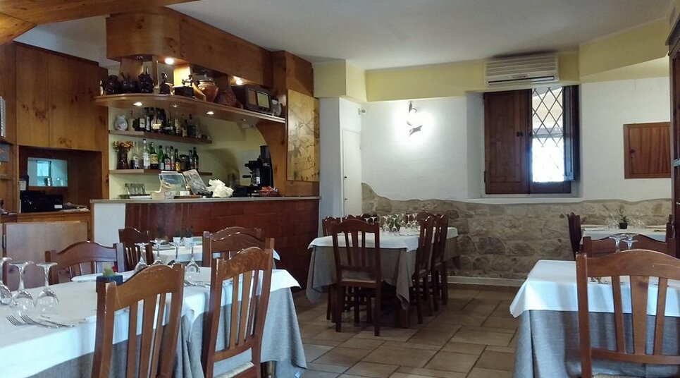 Interno di un ristorante con tavoli apparecchiati, decorazioni rustiche e cucina abruzzese Interno di un ristorante con tavoli apparecchiati, decorazioni rustiche e cucina abruzzese