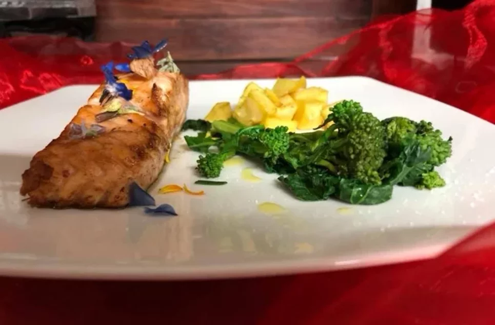 Piatto elegante con filetto decorato con fiori ed erbe, contorno di broccoli e patate a dadini, cucina abruzzese Piatto elegante con filetto decorato con fiori ed erbe, contorno di broccoli e patate a dadini, cucina abruzzese