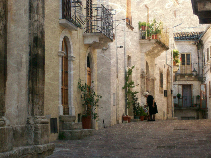 Vicolo pittoresco con balconi e piante in un ambiente storico