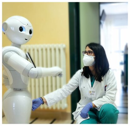 Assistente sanitario interagisce con robot umanoide per riabilitazione e inclusione.