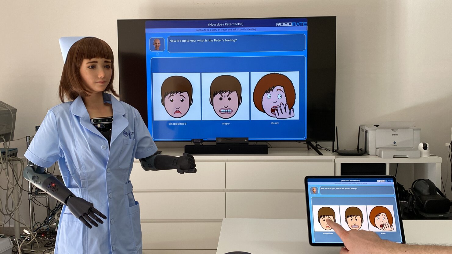 Humanoid robot used in cognitive rehabilitation therapy with RoboMate software on screen