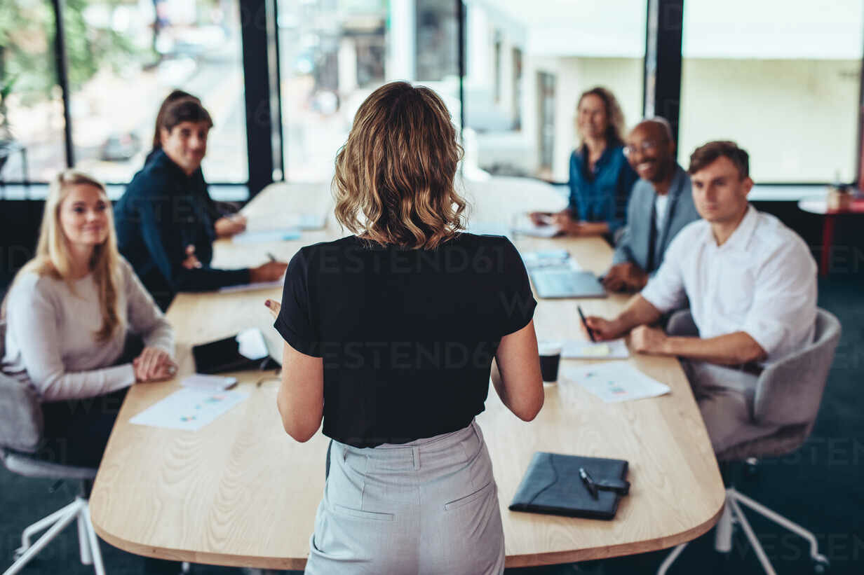 Cuando usted dirige la reunión mujer vista de espalda dirigiendo una reunión en la oficina