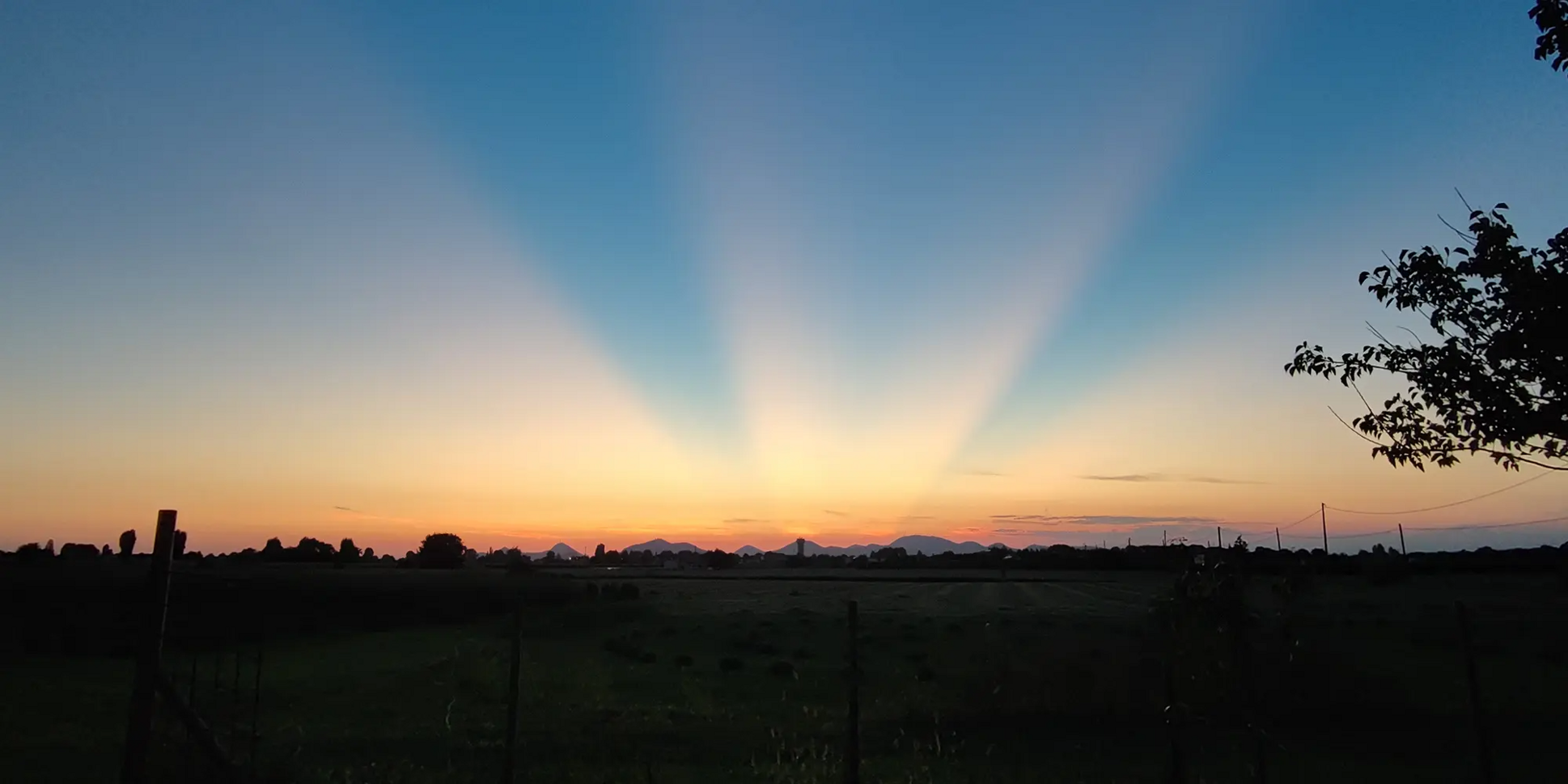 Tramonto su un campo a Conselve con raggi di luce nel cielo