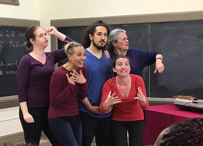 eyJlbiI6IlBsYXliYWNrIE1vbnRyZWFsIHRoZWF0cmUgdHJvdXBlIGluIGZ1bGwgaW1wcm92aXNhdGlvbiBpbiBhIGNsYXNzcm9vbSwgZml2ZSBleHByZXNzaXZlIGFjdG9ycyBpbiBjb2xvdXJmdWwgY29zdHVtZXMgaW4gZnJvbnQgb2YgYSBibGFja2JvYXJkLiIsImZyIjoiVHJvdXBlIGRlIHRo6eJ0cmUgUGxheWJhY2sgTW9udHLpYWwgZW4gcGxlaW5lIGltcHJvdmlzYXRpb24gZGFucyB1bmUgc2FsbGUgZGUgY2xhc3NlLCBjaW5xIGNvbelkaWVucyBleHByZXNzaWZzIGF1eCBjb3N0dW1lcyBjb2xvculzIGRldmFudCB1biB0YWJsZWF1IG5vaXIuIn0=