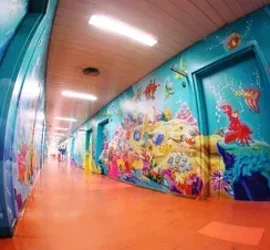 Corridoio decorato con murales a tema marino in un ospedale pediatrico