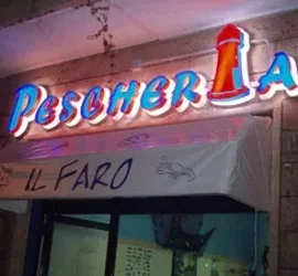 Insegna luminosa di una pescheria con scritto Il Faro.