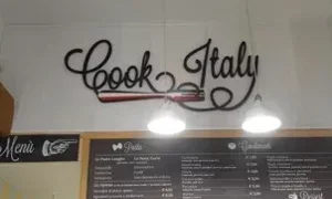 Menu di un ristorante italiano con decorazione murale 'Cook Italy'.