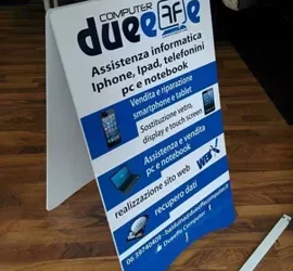 Cartello pubblicitario con servizi di assistenza informatica per iPhone, iPad, telefonini, PC e notebook.