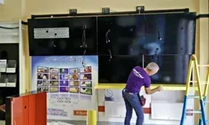 Installazione di un grande schermo televisivo in una sala.