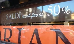 Vetrina negozio con scritta saldi sconti fino al 50 percento