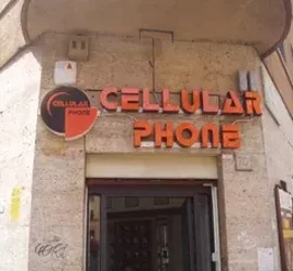 Ingresso di un negozio con insegna Cellular Phone su edificio in pietra