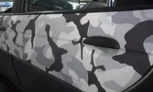 Portiera di un'auto decorata con pellicola mimetica
